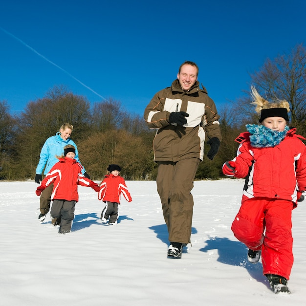 Famille courir dans la neige