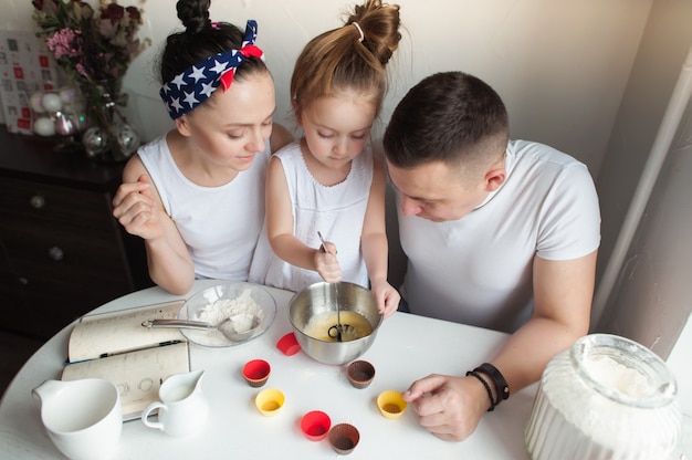 La famille cuit des biscuits dans la cuisine