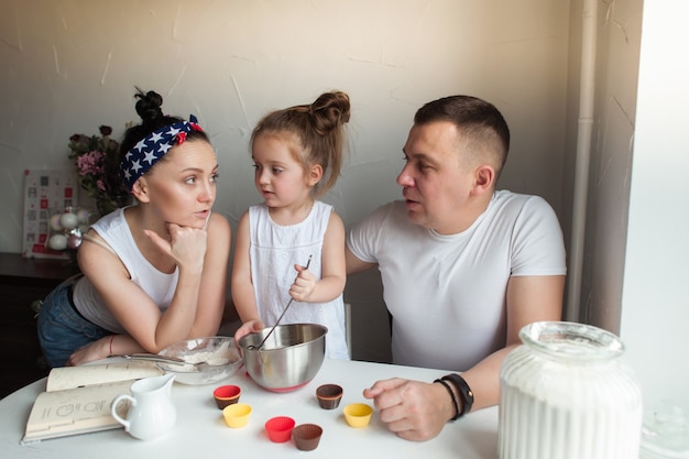 La famille cuit des biscuits dans la cuisine