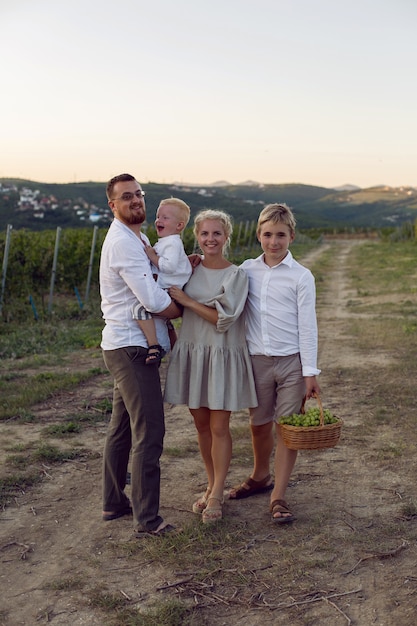 Famille dans un champ de raisin pendant le coucher du soleil en été