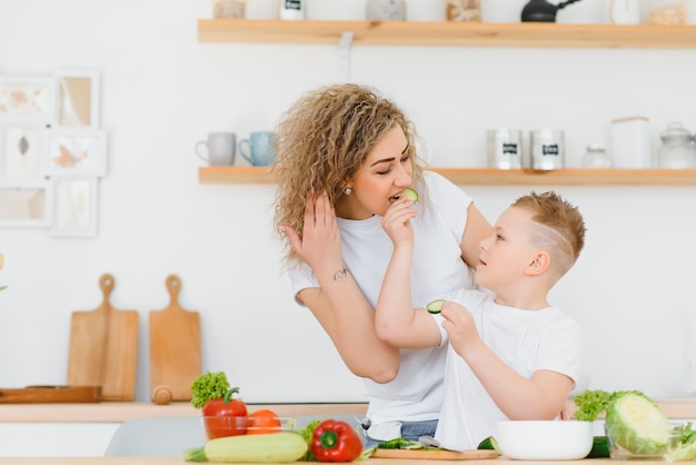 Famille dans une cuisine. Belle mère avec enfants. Dame en chemisier blanc.