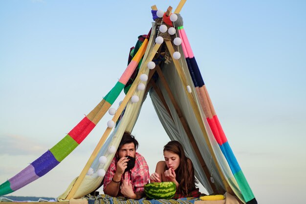 Famille dans la tente Couple amoureux manger au camping Homme fumeur avec femme au pique-nique en plein air