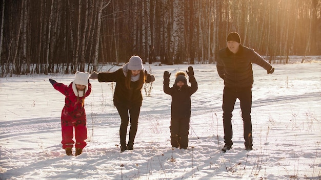 Famille debout à l'extérieur en hiver et sur le point de sauter en l'air