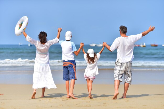 Famille debout sur la plage de sable