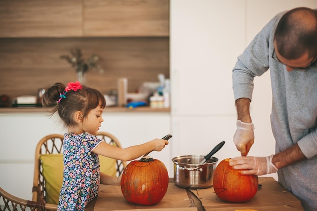 Famille découpant des citrouilles pour Halloween