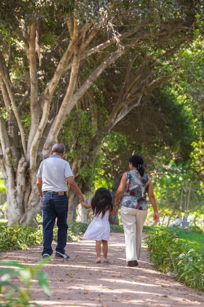 Une famille descend un chemin avec un arbre en arrière-plan.