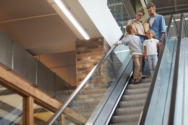 Famille avec deux enfants descendant l'escalator