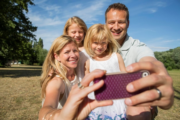 Photo famille avec deux enfants prenant un selfie