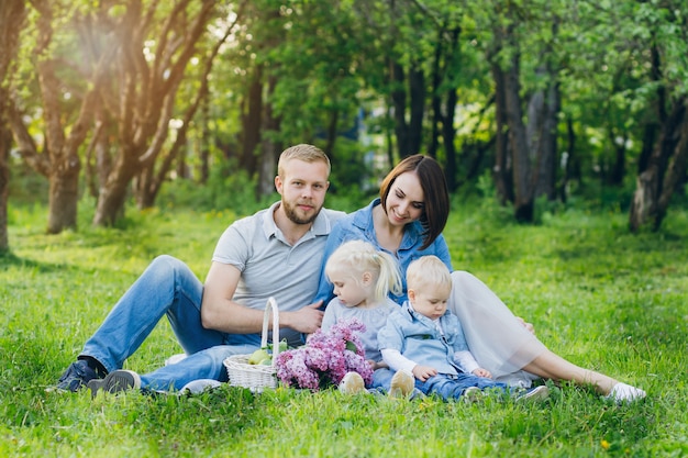 Famille avec deux enfants se reposent dans le jardin d'été