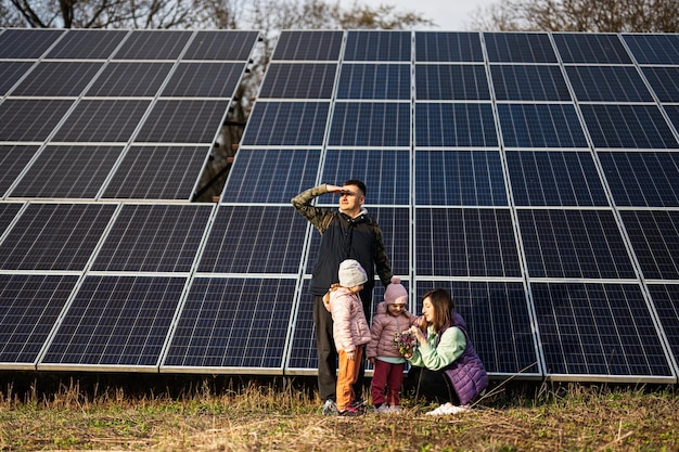 Famille avec deux filles sur fond de panneaux solaires Eco energy