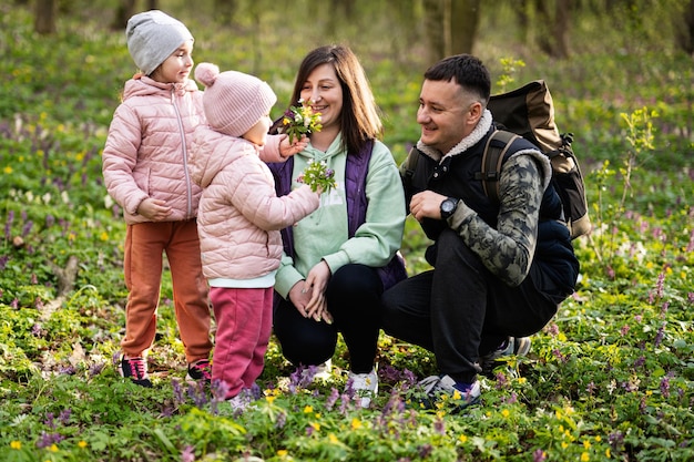 Famille avec deux filles sur la forêt ensoleillée Concept de loisirs de printemps en plein air