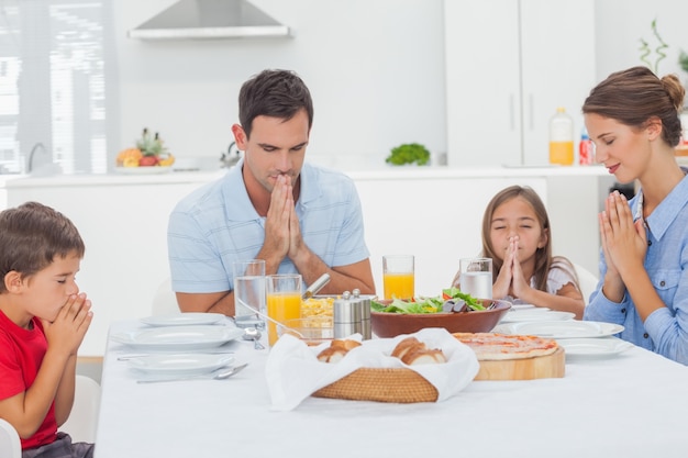 Famille disant grâce avant le dîner