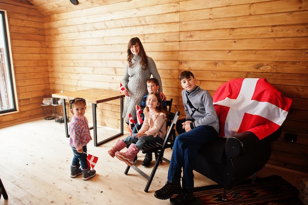 Famille avec drapeaux danois à l'intérieur d'une maison en bois Voyage dans les pays scandinaves Peuples danois les plus heureux