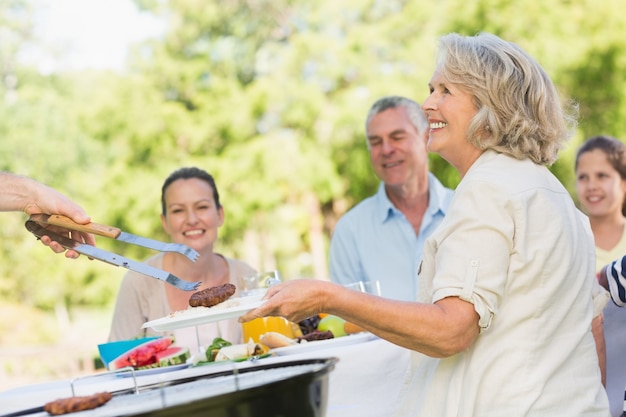 Famille élargie à manger à la table en plein air