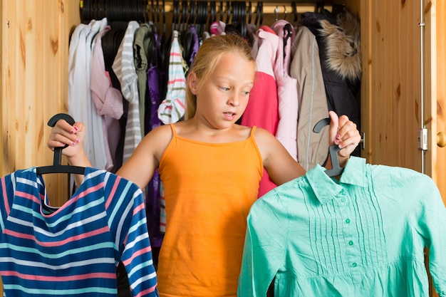 Famille, enfant devant son placard ou sa garde-robe