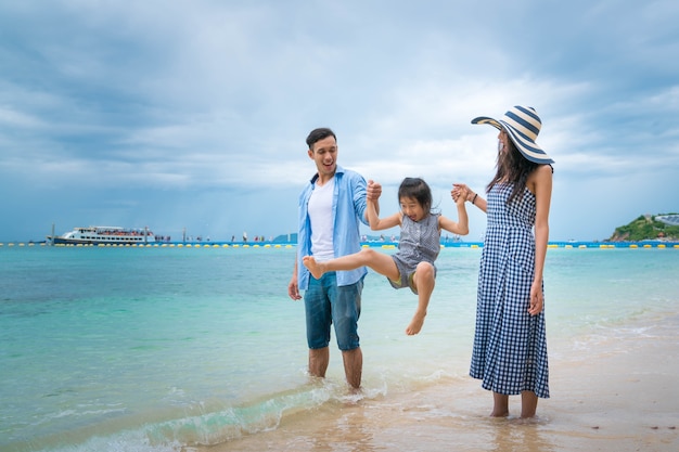 Photo famille avec enfant jouant sur la plage