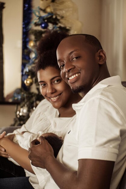 Famille ensemble à l'intérieur de la maison souriant en regardant la caméra concept de Noël