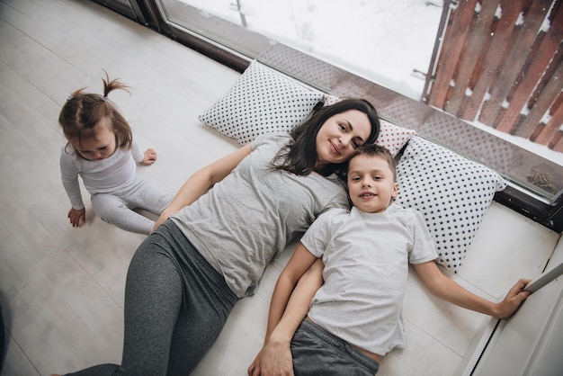 La famille est assise à la fenêtre et regarde la forêt d'hiver. Bon esprit du nouvel an. Matin en pyjama.