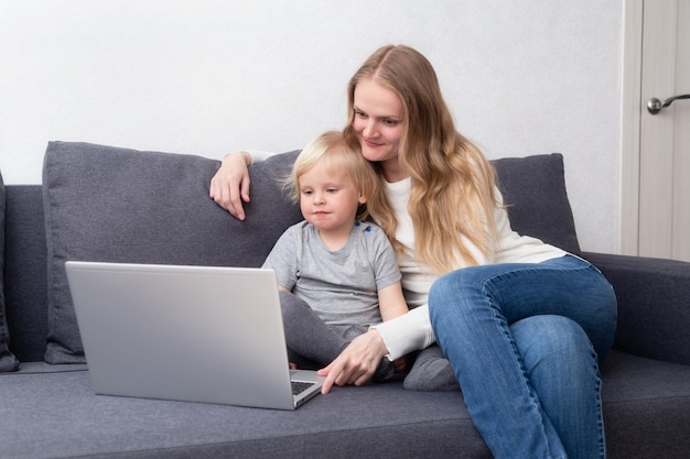 Une famille est assise à la maison avec un ordinateur portable.