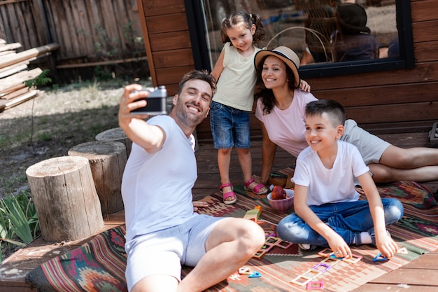 la famille est photographiée sur un appareil photo argentique le père prend un selfie avec sa femme et ses enfants