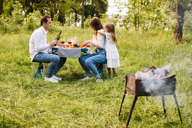 Photo famille faisant un barbecue dans la nature