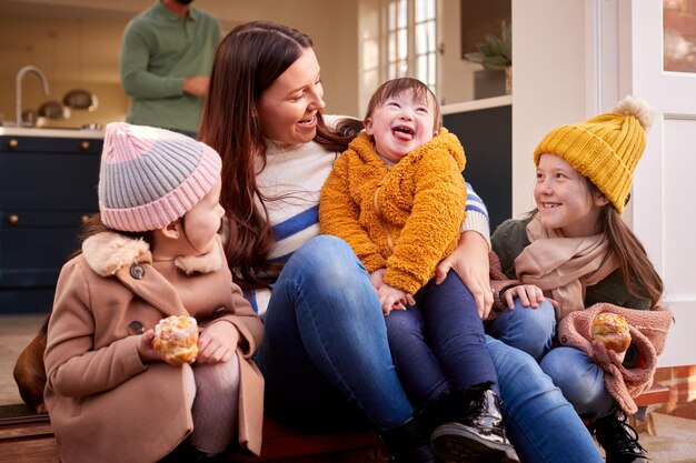 Famille avec fille trisomique se prépare à partir pour l'automne ou l'hiver marcher ensemble