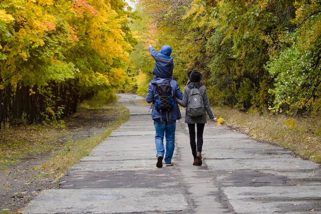 Famille avec fils se promènent dans le parc d'automne Vue arrière