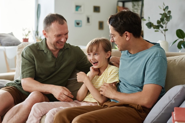 Famille gay s'amusant avec sa fille adoptive à la maison