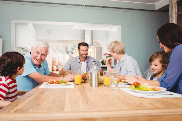 Photo famille avec les grands-parents discutant à la table à manger