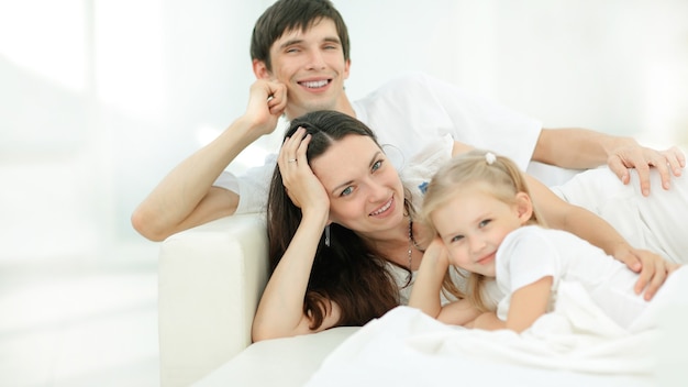 Famille heureuse allongée sur le canapé le dimanche.photo avec espace de copie