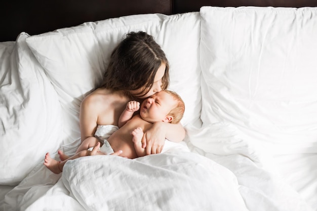 Famille heureuse allongée sous une couverture au lit à la maison