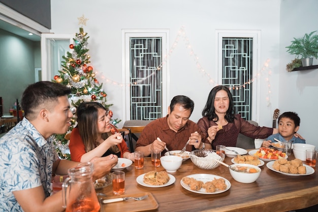 Famille heureuse asiatique célébrant Noël ensemble à la maison