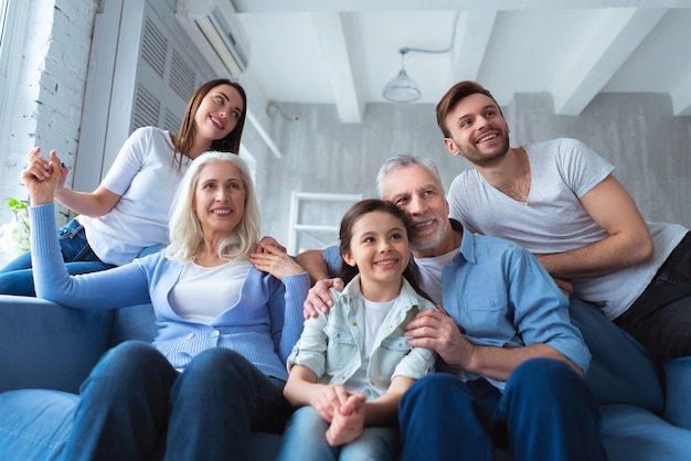 La famille heureuse assise sur le canapé