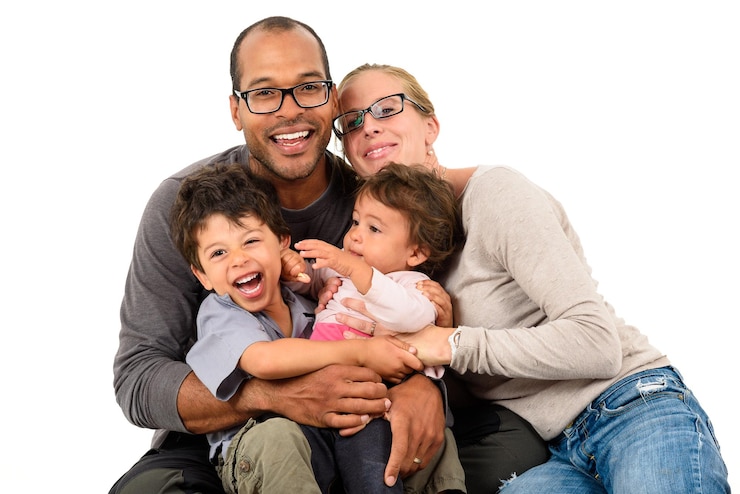 Photo une famille heureuse assise sur un fond blanc.