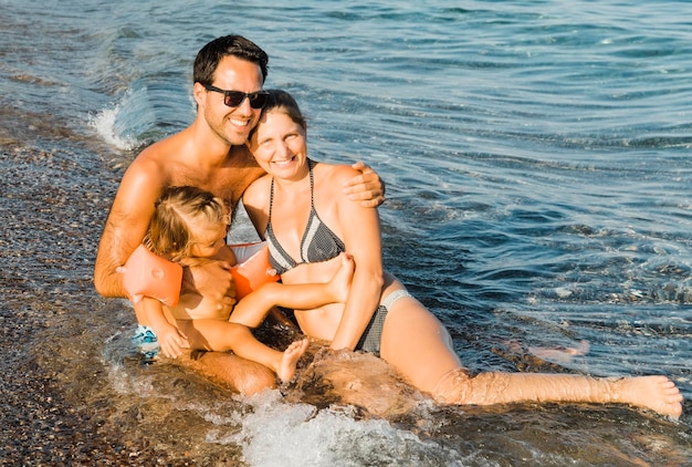 Une famille heureuse assise sur le rivage