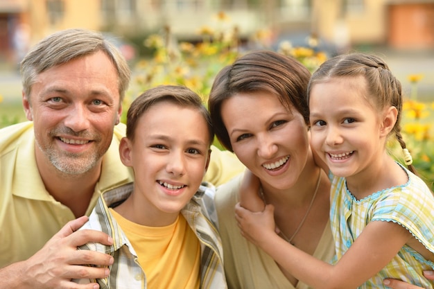 Famille heureuse au champ de floraison vert d'été