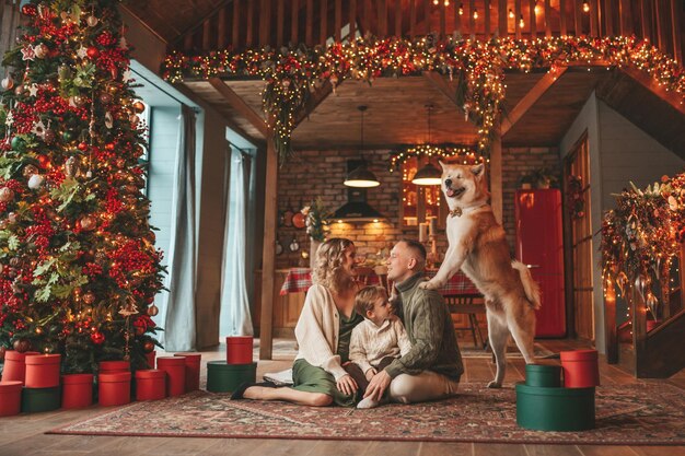 Famille heureuse et authentique pendant l'hiver, profitant ensemble de vacances avec un chien à Noël