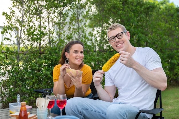 Famille heureuse ayant un barbecue barbecue avec du vin rouge dans le jardin extérieur de la maison avec heureux