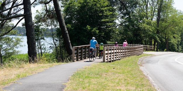 Famille heureuse en balade à vélo sur le pont du lac de Lacanau dans le modèle de bannière web