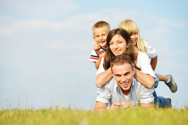 Famille heureuse sur la belle prairie d&#39;été ayant du bon temps