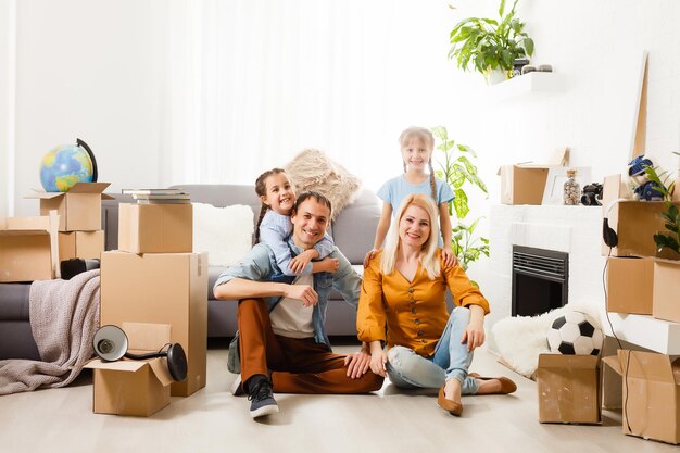 Famille heureuse avec des boîtes en carton dans la nouvelle maison le jour du déménagement.