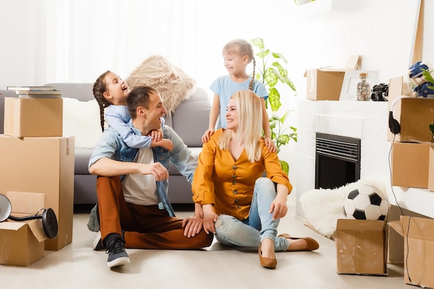 Famille heureuse avec des boîtes en carton dans la nouvelle maison le jour du déménagement.