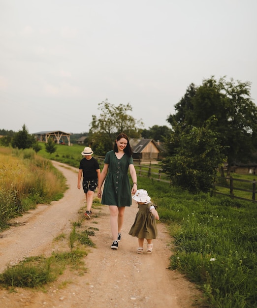 Famille heureuse Bonne maman joue avec les enfants à l'extérieur en été