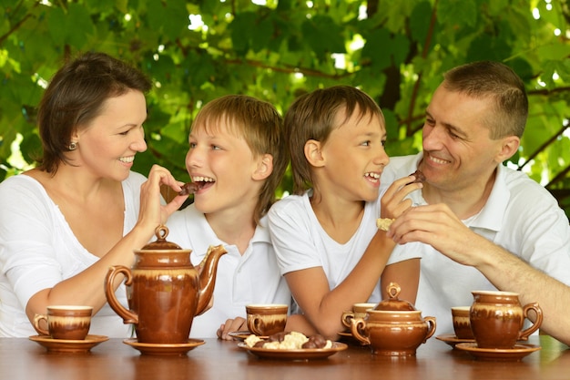 Famille heureuse buvant du thé dans le jardin d'été