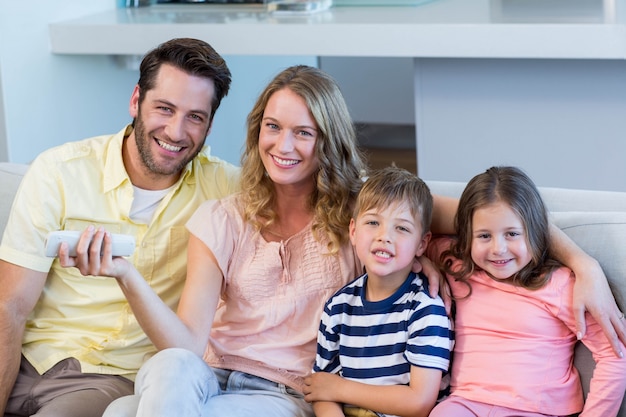 Famille heureuse sur le canapé en regardant la télévision