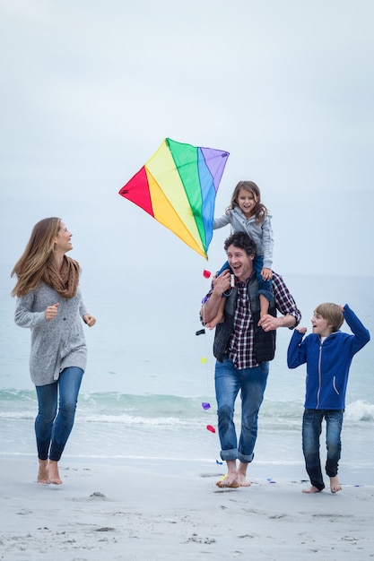 Famille heureuse avec cerf-volant en bord de mer