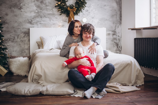 Famille heureuse, chez soi, lit, près, arbre noël