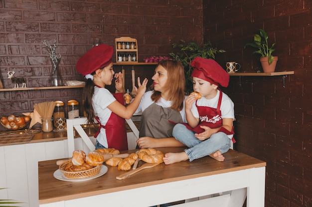 Famille heureuse dans la cuisine. maman et les enfants préparent la pâte, font des biscuits. fête des mères.