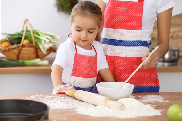 Famille heureuse dans la cuisine Mère et enfant fille cuisinant une tarte ou des biscuits de vacances pour la fête des mères