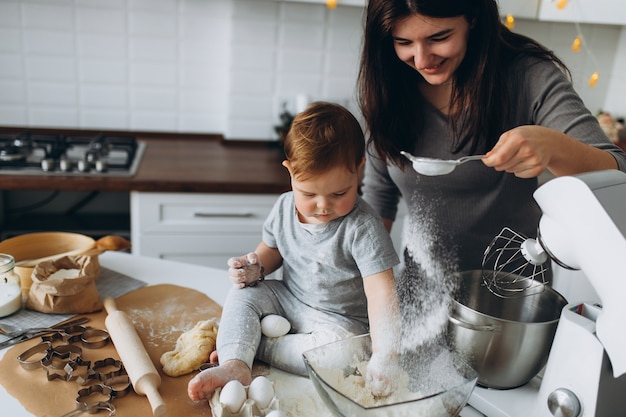 Famille heureuse dans la cuisine. mère et fils, préparer la pâte, faire cuire les cookies